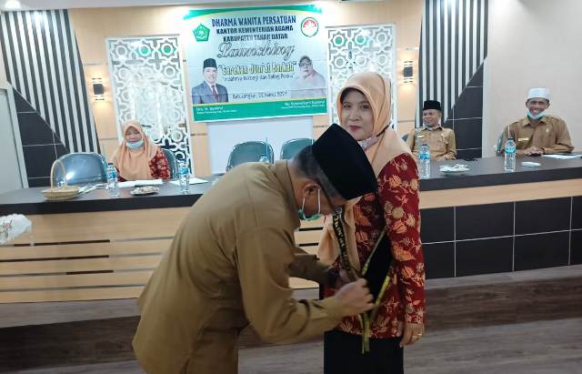 Kakankemenag Tanahdatar H.Syahrul memasangkan slempang pada Ketua DWP Kemenag Tanahdatar Ny.Syamsibarti Syahrul.